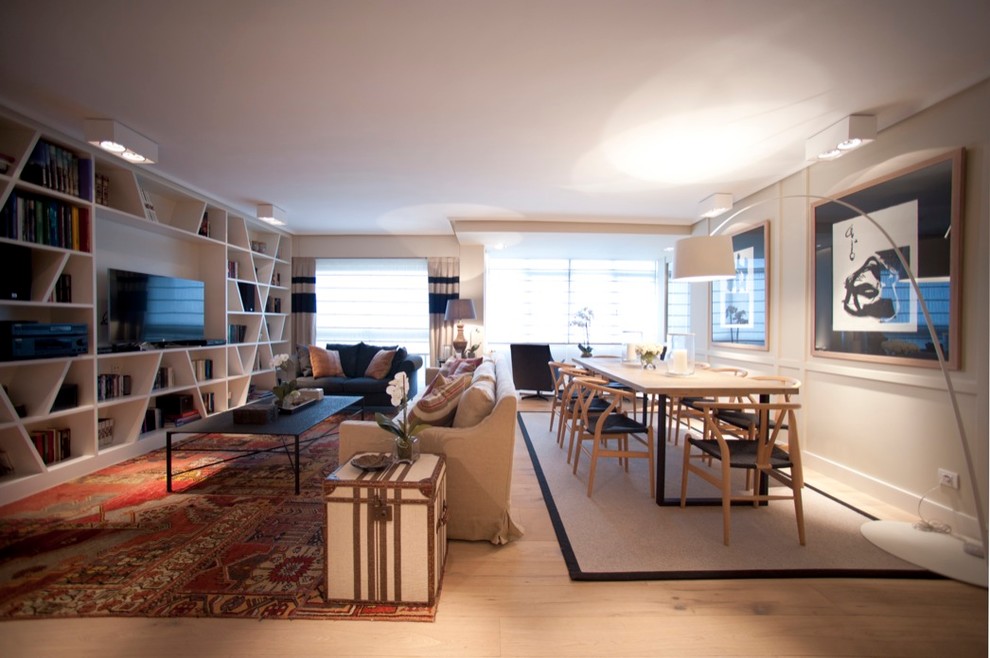 Foto de salón abierto contemporáneo con paredes beige, suelo de madera clara y pared multimedia
