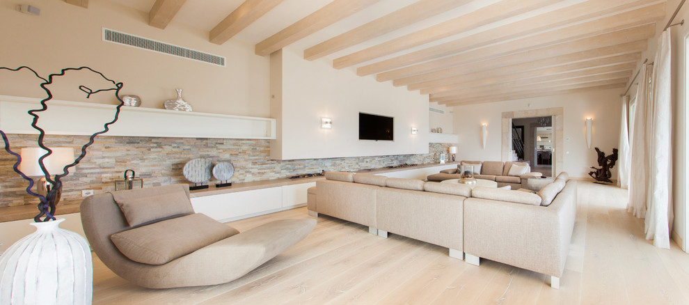 Ejemplo de salón para visitas cerrado nórdico grande con paredes beige, suelo de madera clara y televisor colgado en la pared