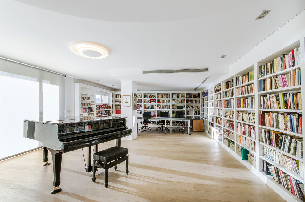 Foto de biblioteca en casa cerrada tradicional renovada grande sin chimenea y televisor con paredes blancas y suelo de madera clara