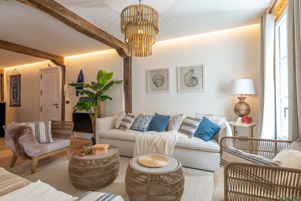 Ispirazione per un grande soggiorno stile marinaro aperto con pareti bianche, parquet chiaro e pavimento beige