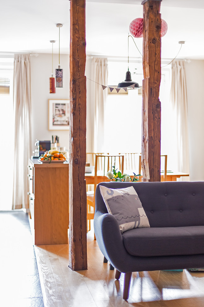 Imagen de salón abierto rural grande con paredes beige, suelo de madera en tonos medios y suelo marrón