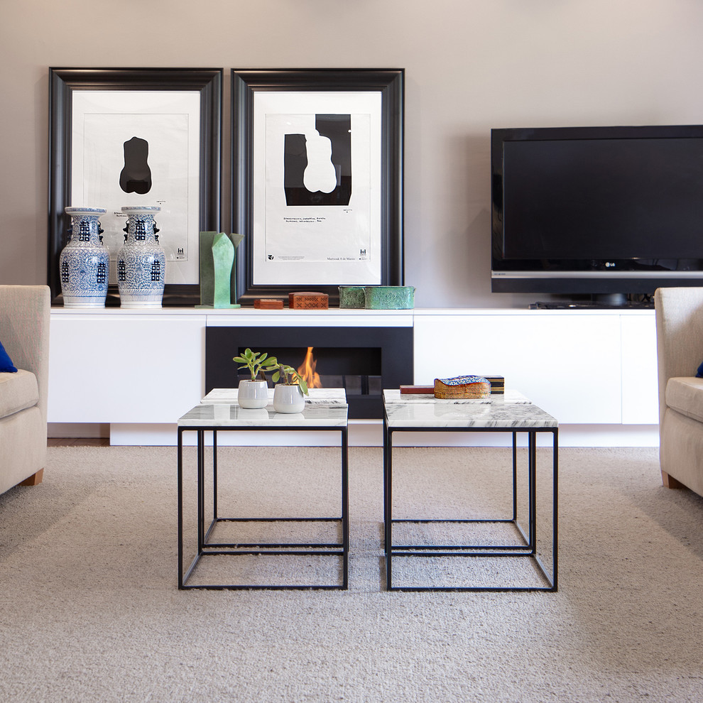 Diseño de salón abierto bohemio de tamaño medio con paredes grises, moqueta, chimenea lineal, marco de chimenea de metal, televisor independiente y suelo gris