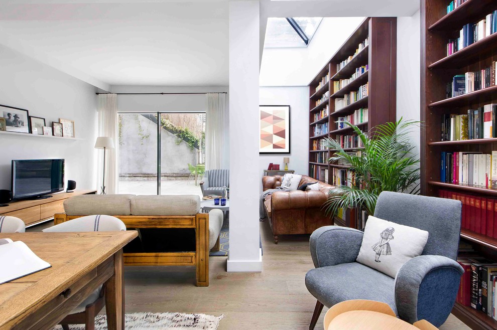 Esempio di un soggiorno minimalista di medie dimensioni e aperto con libreria, pareti bianche, pavimento in legno massello medio, nessun camino e parete attrezzata