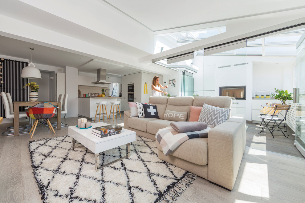 Foto di un soggiorno design di medie dimensioni e aperto con pareti bianche, pavimento in laminato e camino classico
