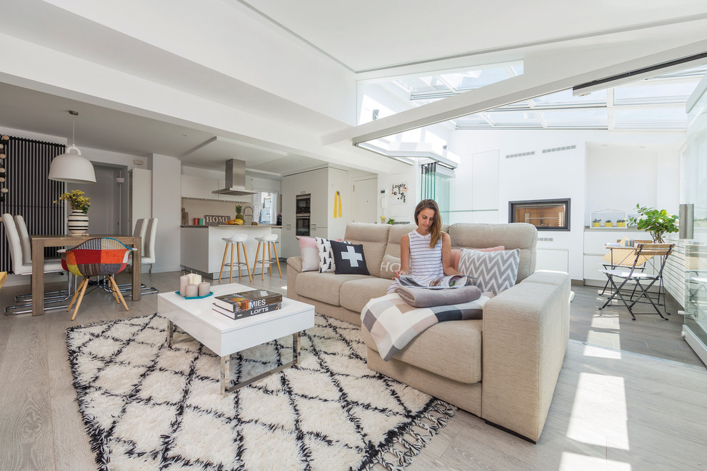 Immagine di un soggiorno design di medie dimensioni e aperto con pareti bianche, pavimento in laminato e camino classico