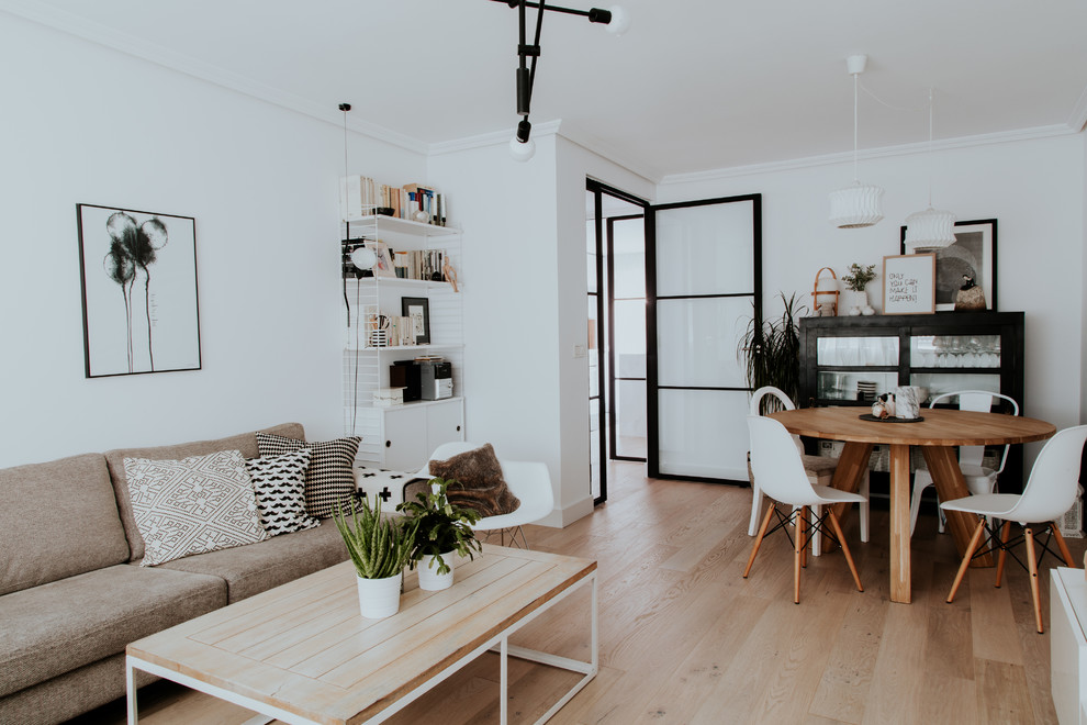 Exempel på ett stort minimalistiskt separat vardagsrum, med vita väggar, ljust trägolv, en fristående TV och brunt golv