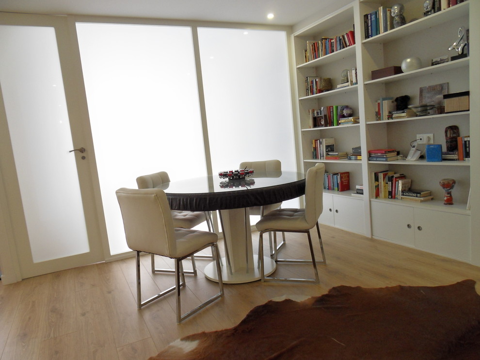 Inspiration pour un salon minimaliste de taille moyenne et ouvert avec un mur blanc, parquet clair, une bibliothèque ou un coin lecture et aucune cheminée.