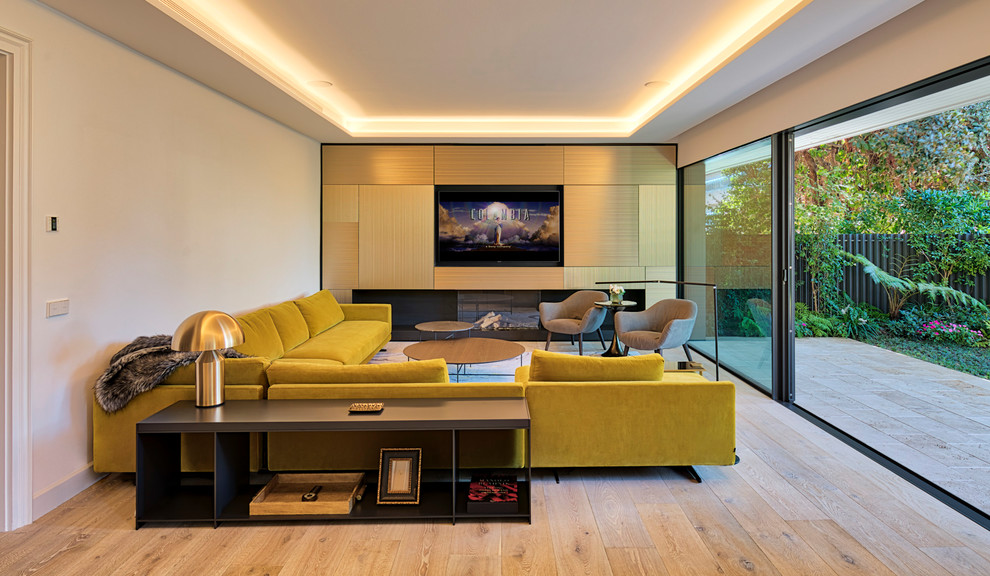 Repräsentatives, Abgetrenntes Modernes Wohnzimmer mit weißer Wandfarbe, hellem Holzboden, Gaskamin, verputzter Kaminumrandung, Multimediawand und beigem Boden in Barcelona