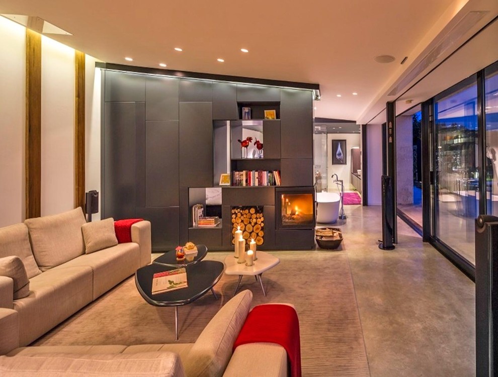 Diseño de salón para visitas abierto contemporáneo de tamaño medio con paredes multicolor, chimenea de doble cara y televisor independiente