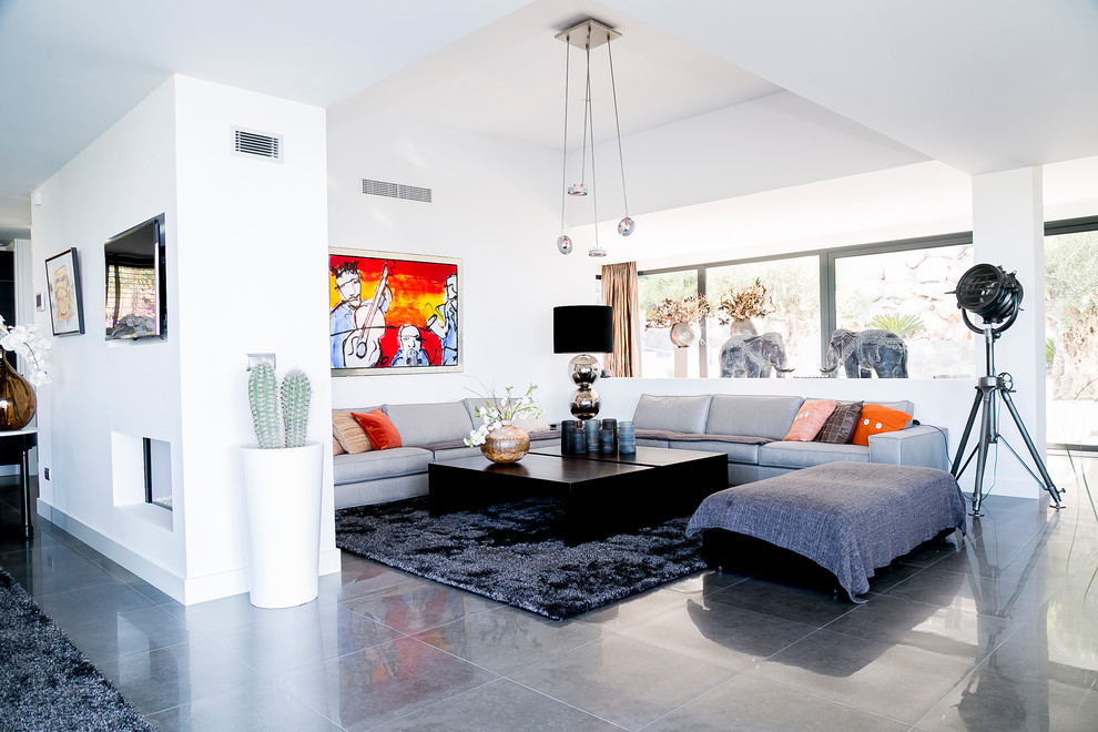 Ispirazione per un soggiorno minimal con pareti bianche, camino bifacciale e pavimento grigio