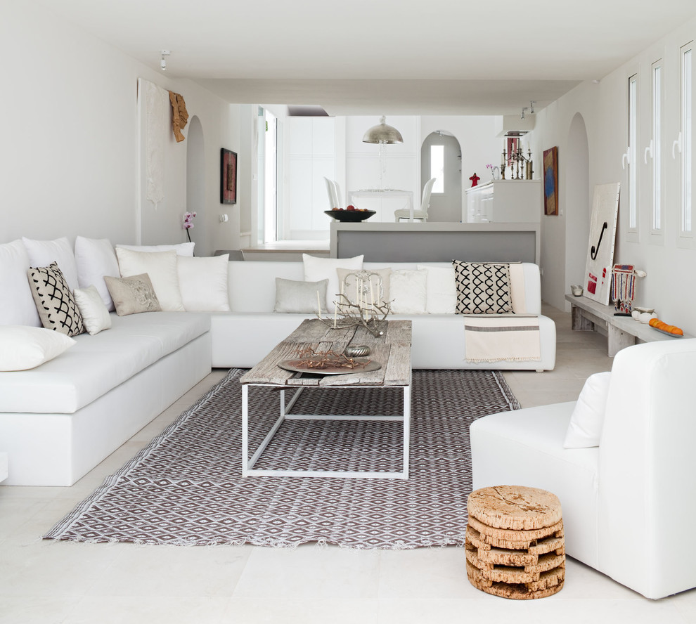 Imagen de salón para visitas abierto mediterráneo grande sin chimenea y televisor con paredes blancas, suelo de travertino y alfombra