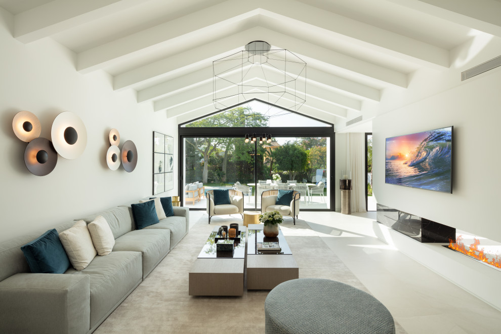 Design ideas for an expansive mediterranean open plan living room in Other with white walls, a ribbon fireplace, a wall mounted tv and beige floors.