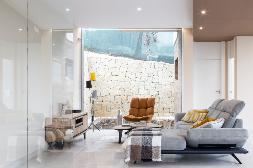 Imagen de salón abierto actual de tamaño medio sin chimenea y televisor con paredes blancas y suelo gris
