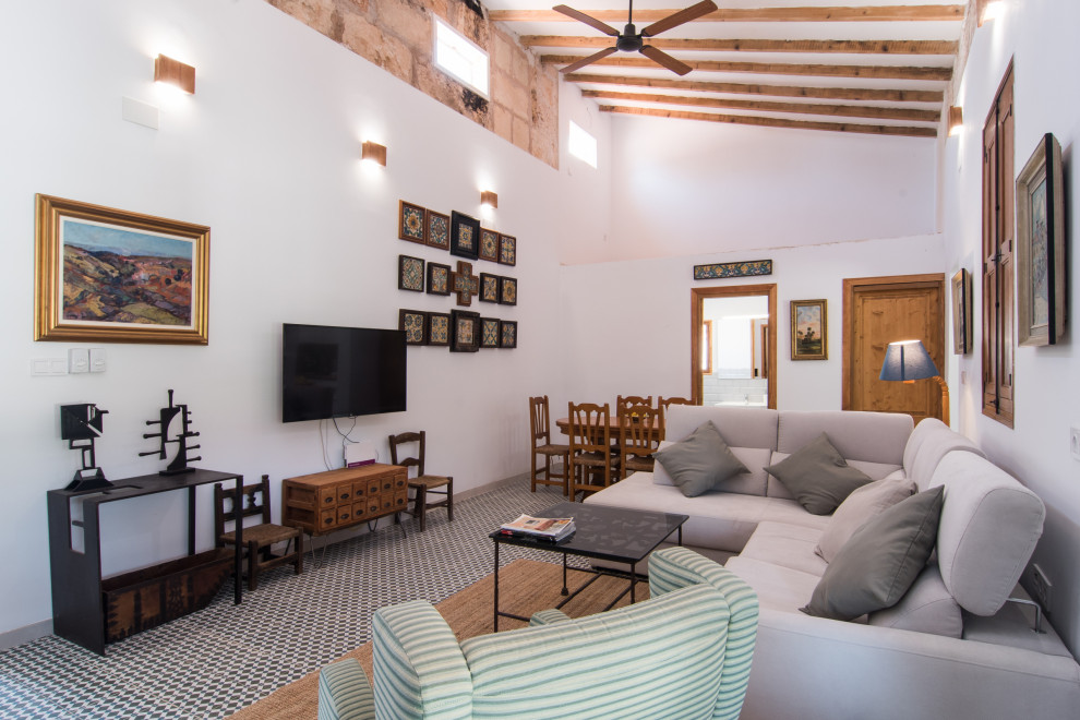 Ejemplo de salón abierto mediterráneo con paredes blancas, suelo multicolor y vigas vistas
