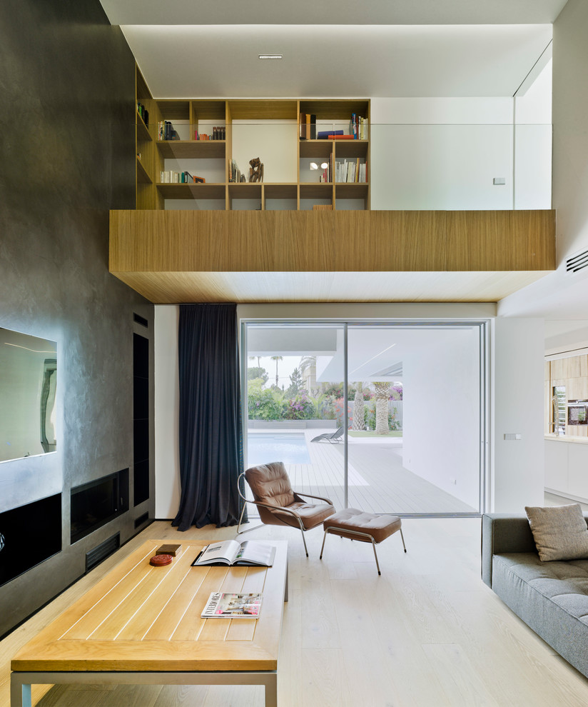 Пример оригинального дизайна: большая парадная, открытая гостиная комната в современном стиле с серыми стенами, светлым паркетным полом и телевизором на стене