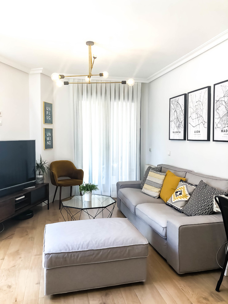 Diseño de salón actual con paredes blancas, suelo de madera clara, televisor independiente y suelo beige