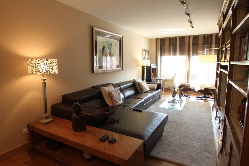 Immagine di un grande soggiorno classico aperto con pareti beige, pavimento in legno massello medio e parete attrezzata