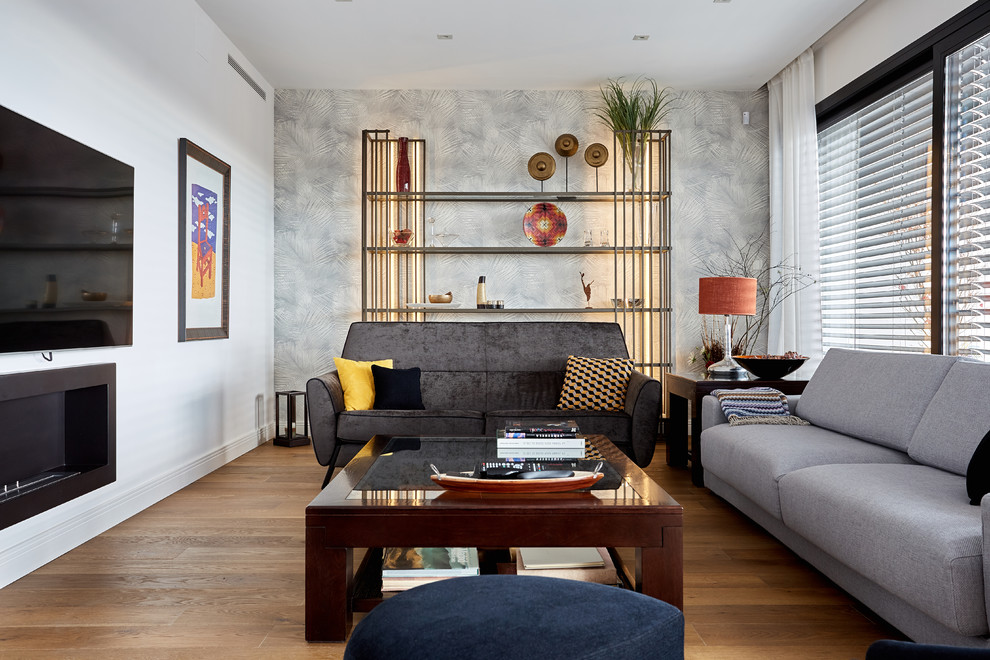 Стильный дизайн: парадная, изолированная гостиная комната в современном стиле с белыми стенами, паркетным полом среднего тона, горизонтальным камином, фасадом камина из металла, телевизором на стене и коричневым полом - последний тренд