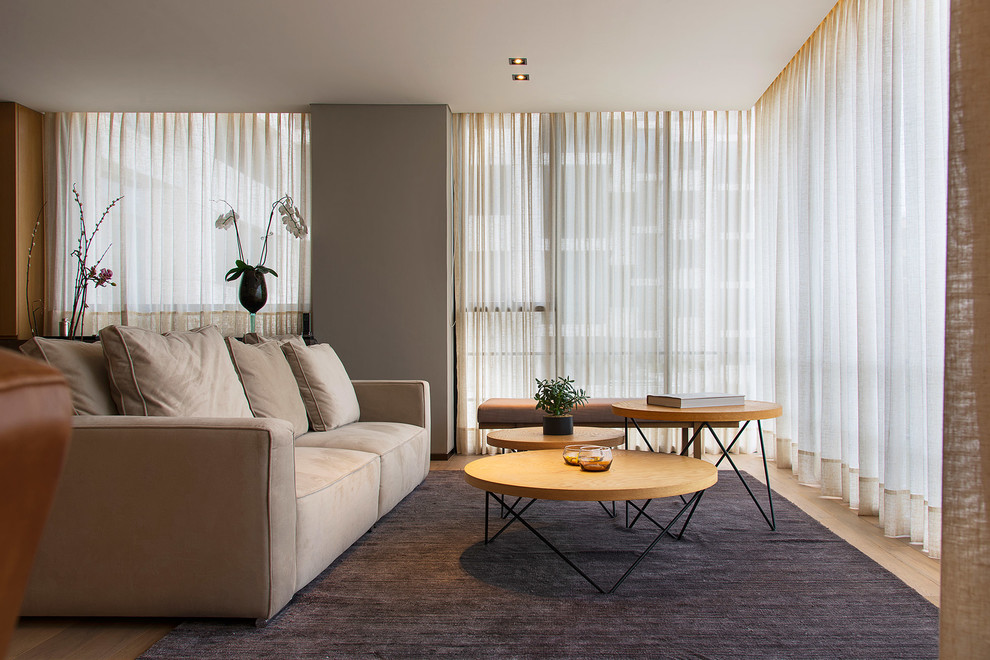 Modernes Wohnzimmer mit grauer Wandfarbe, braunem Holzboden und braunem Boden in Sonstige