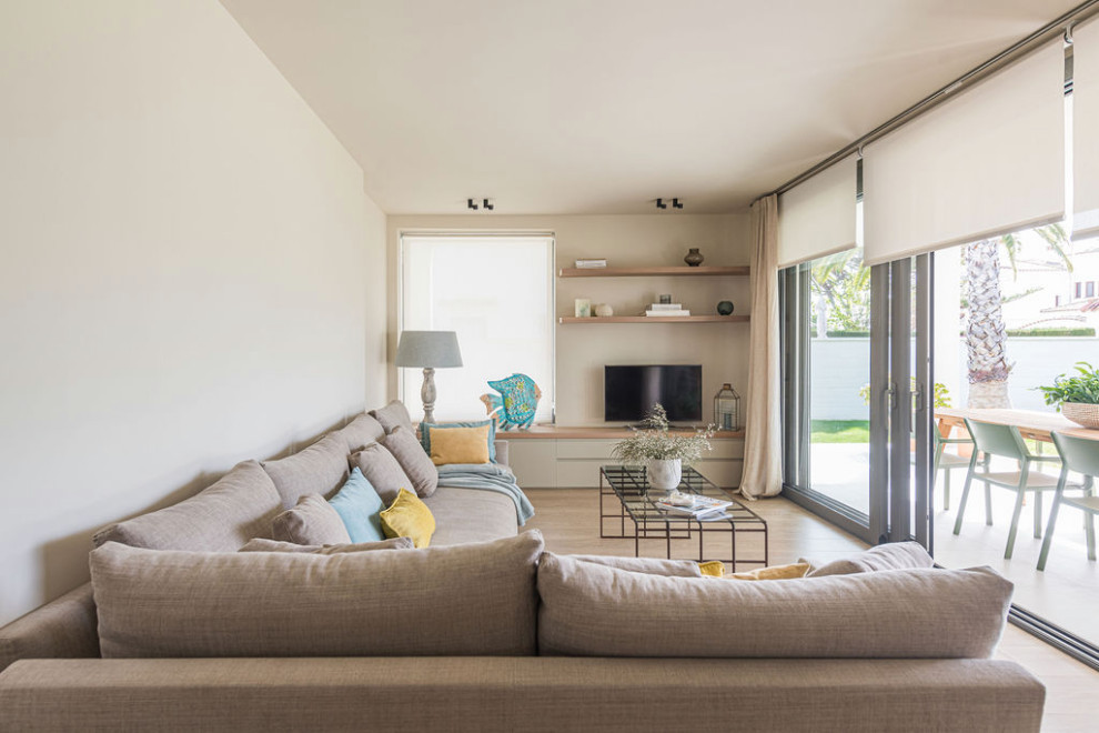 Idee per un grande soggiorno mediterraneo aperto con pareti bianche, parquet chiaro e porta TV ad angolo