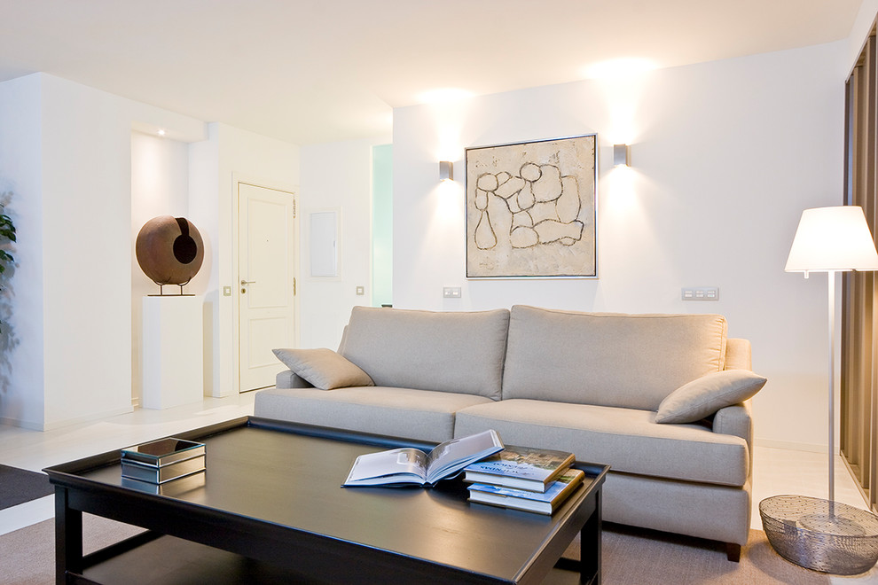 Modelo de salón abierto actual de tamaño medio con paredes blancas, suelo de madera clara, pared multimedia y suelo blanco