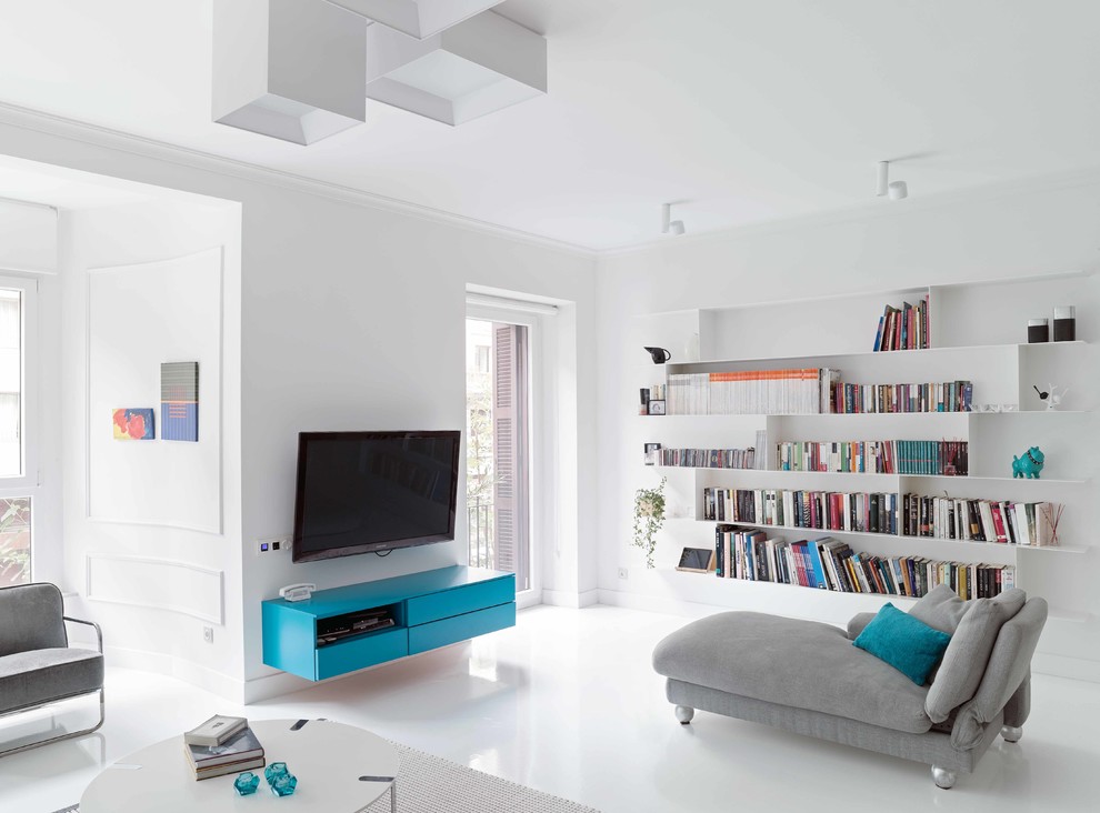 Modern inredning av ett stort allrum med öppen planlösning, med ett bibliotek, vita väggar, betonggolv och en väggmonterad TV