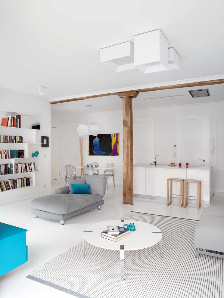 Пример оригинального дизайна: большая открытая гостиная комната в современном стиле с с книжными шкафами и полками, белыми стенами, бетонным полом и телевизором на стене