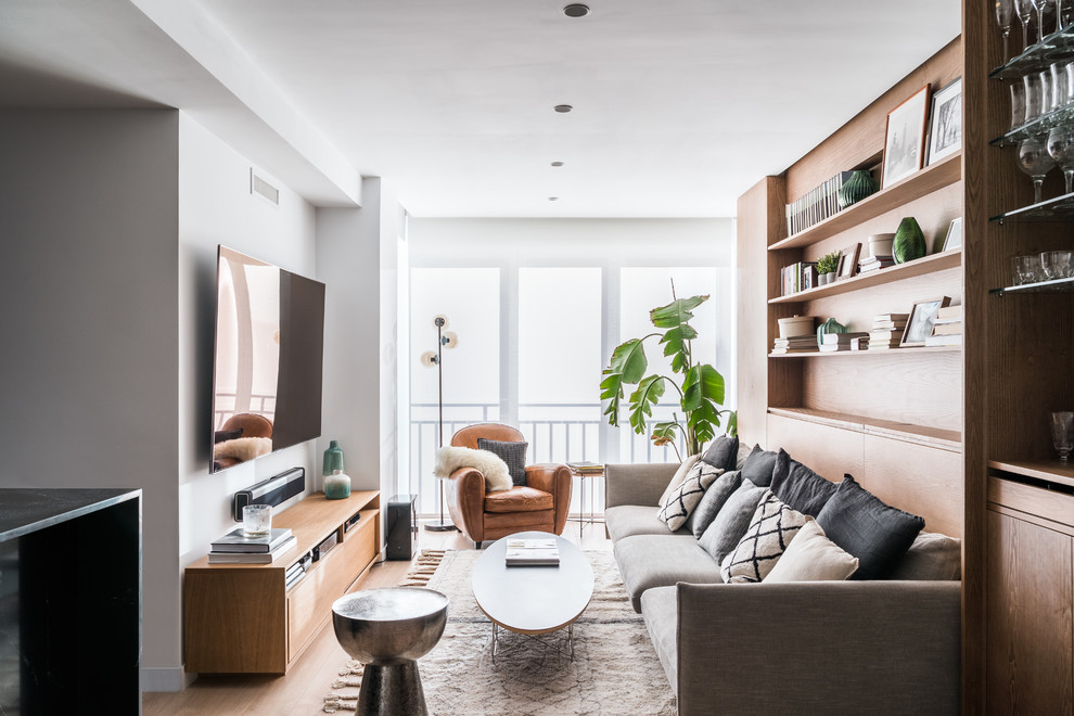 Inspiration pour un salon design avec un mur blanc, un sol en bois brun, un téléviseur fixé au mur et un sol marron.