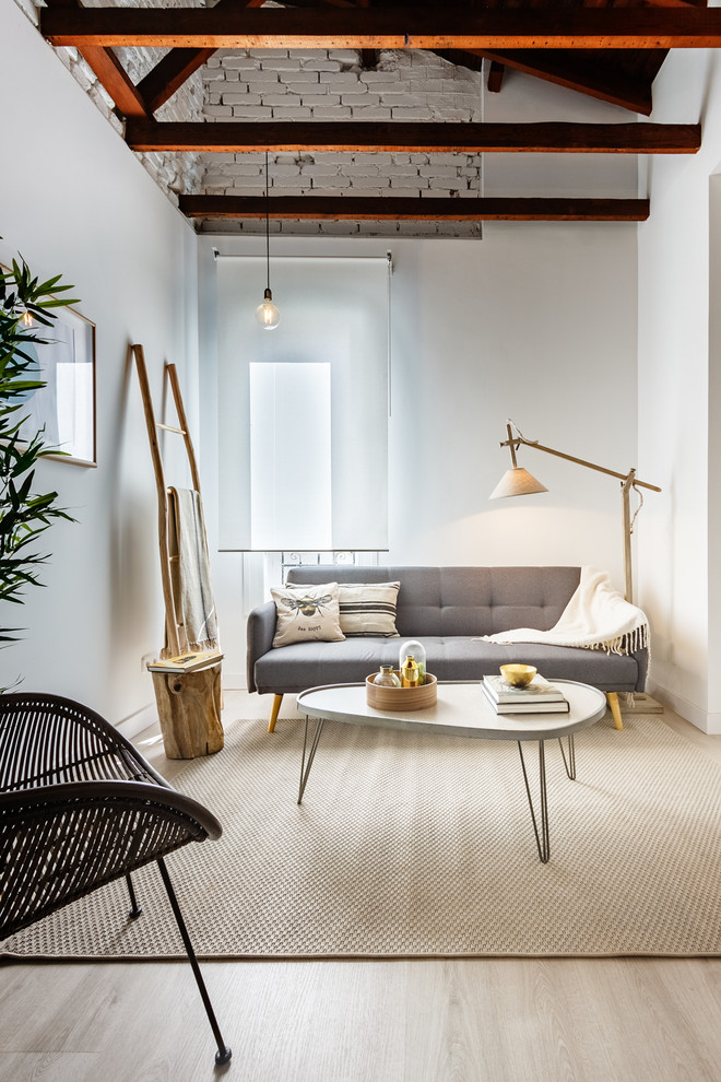 Example of a small danish light wood floor and beige floor living room design in Madrid with white walls, no fireplace and no tv