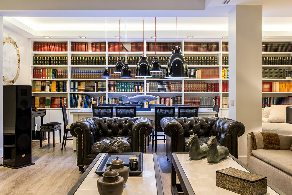 Imagen de biblioteca en casa abierta contemporánea grande sin chimenea con paredes blancas y suelo de madera en tonos medios