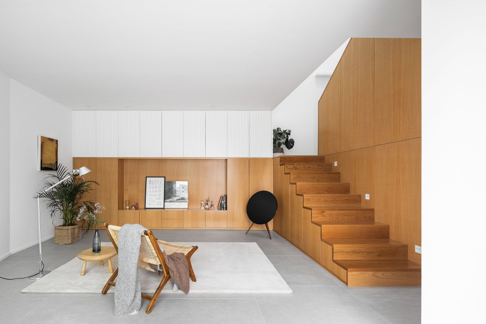 Diseño de salón abierto y abovedado minimalista con paredes marrones, suelo gris y madera