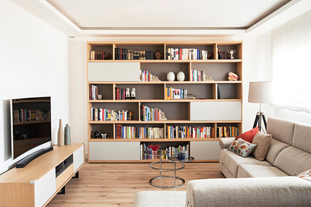 Ispirazione per un piccolo soggiorno minimal aperto con libreria, pareti bianche, pavimento in legno massello medio, nessun camino, TV autoportante e pavimento marrone