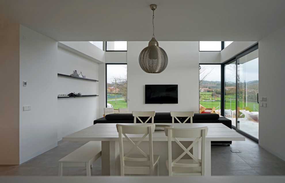 Esempio di un grande soggiorno minimalista aperto con pareti bianche, pavimento con piastrelle in ceramica, TV a parete e pavimento grigio