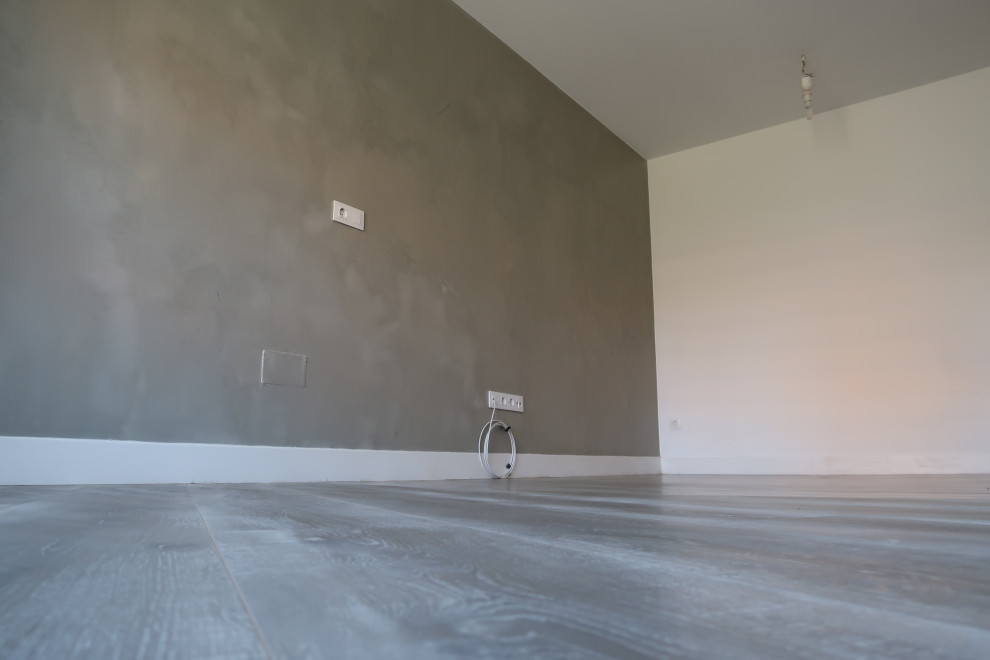 Inspiration pour un salon urbain de taille moyenne et fermé avec sol en stratifié, un téléviseur fixé au mur et un sol gris.