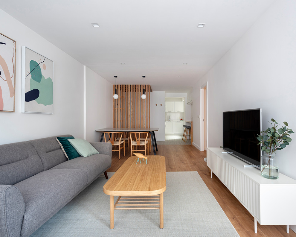 Cette photo montre un salon tendance de taille moyenne avec un mur blanc, un sol en bois brun et un sol marron.