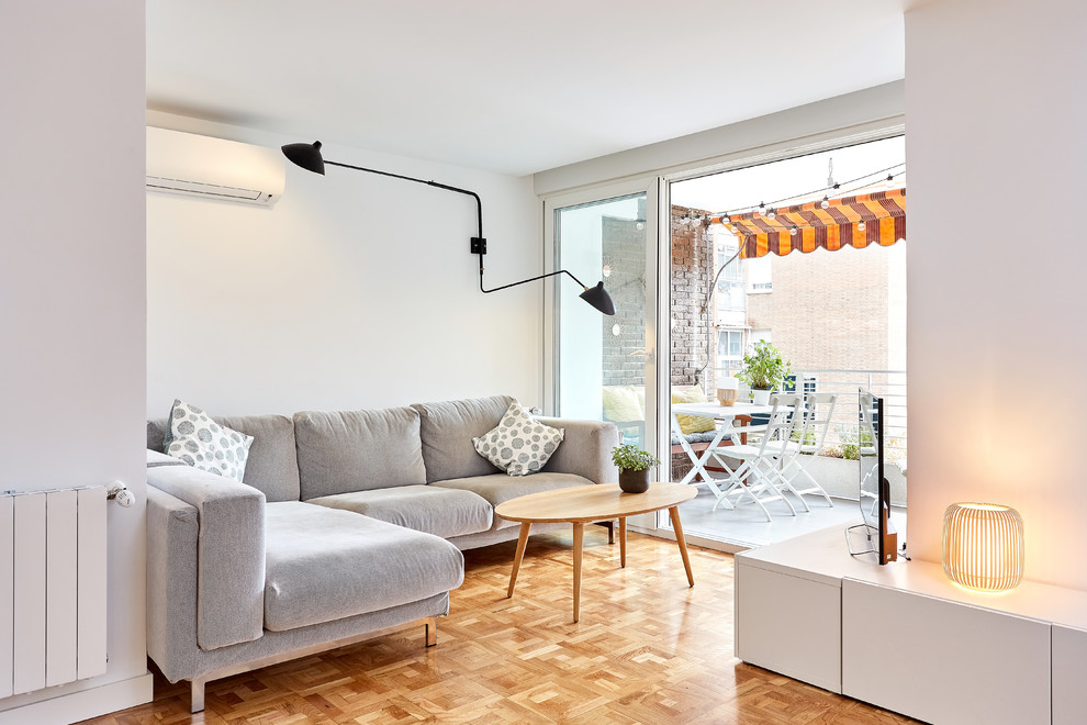 Immagine di un soggiorno contemporaneo con pareti bianche, pavimento in legno massello medio, TV autoportante e pavimento marrone