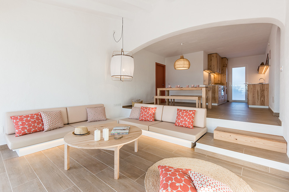 Стильный дизайн: большая открытая гостиная комната в средиземноморском стиле с белыми стенами и полом из керамогранита без камина - последний тренд