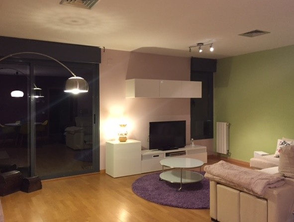 Immagine di un grande soggiorno minimalista chiuso con pareti multicolore, pavimento in legno massello medio, camino bifacciale, cornice del camino in pietra e TV autoportante