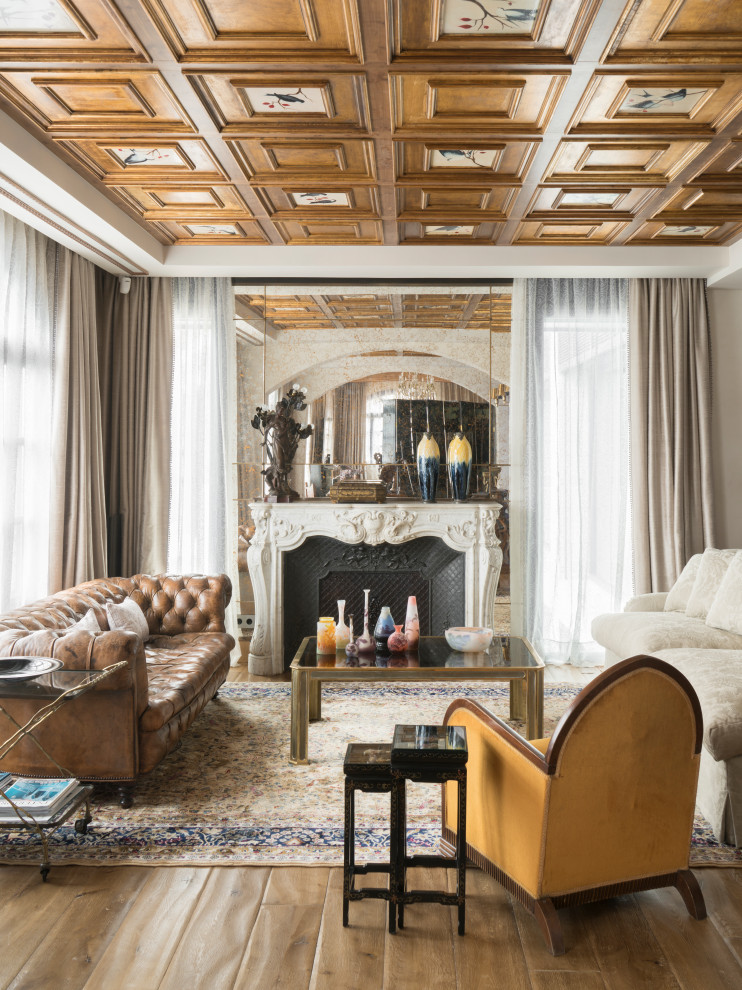 Aménagement d'un grand salon méditerranéen avec une salle de réception, un mur blanc, un sol en bois brun, une cheminée standard, un manteau de cheminée en métal et un sol beige.