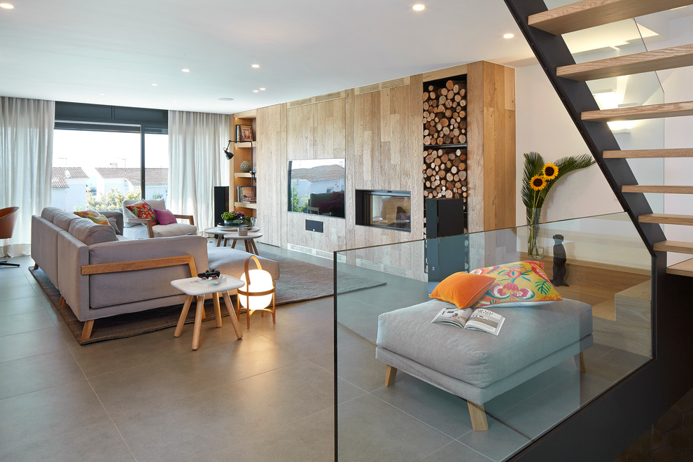 Diseño de salón para visitas abierto contemporáneo de tamaño medio con paredes blancas, suelo de baldosas de cerámica, estufa de leña y televisor colgado en la pared