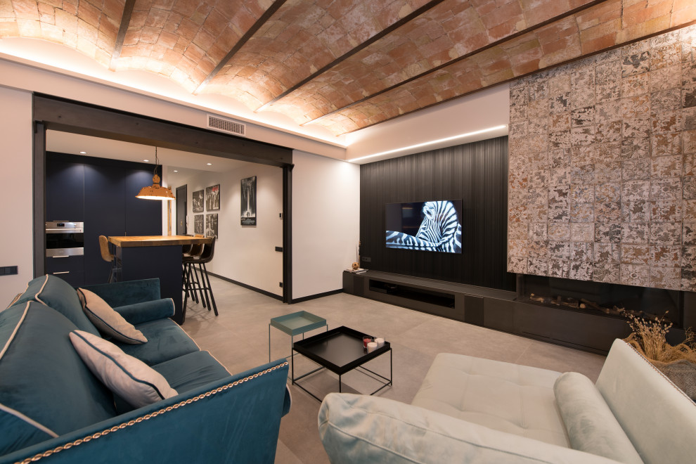 На фото: большая открытая гостиная комната в стиле лофт с серыми стенами, полом из керамогранита, двусторонним камином, фасадом камина из плитки, телевизором на стене, серым полом, сводчатым потолком и кирпичными стенами