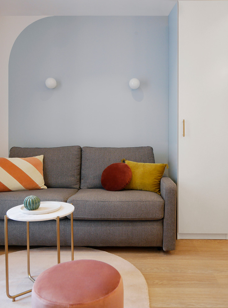 Imagen de salón abierto minimalista pequeño con paredes azules, suelo vinílico, televisor colgado en la pared y suelo beige