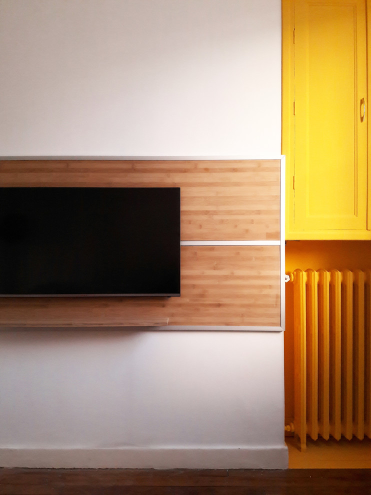 Inspiration pour un petit salon design fermé avec un mur jaune, parquet foncé et un téléviseur fixé au mur.