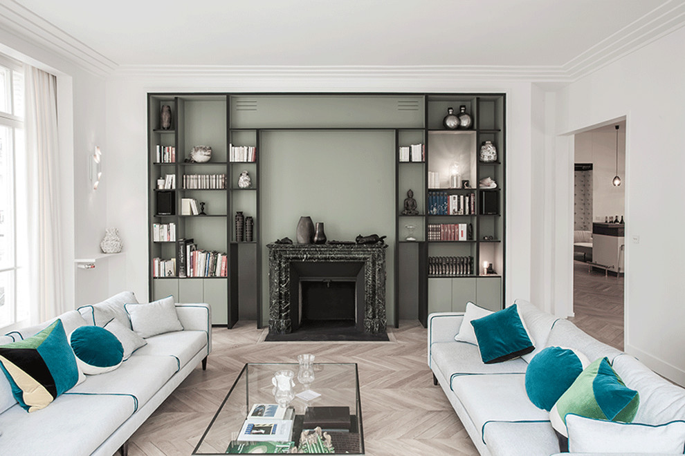 Esempio di un ampio soggiorno design aperto con sala formale, pareti verdi, parquet chiaro, cornice del camino in pietra e nessuna TV