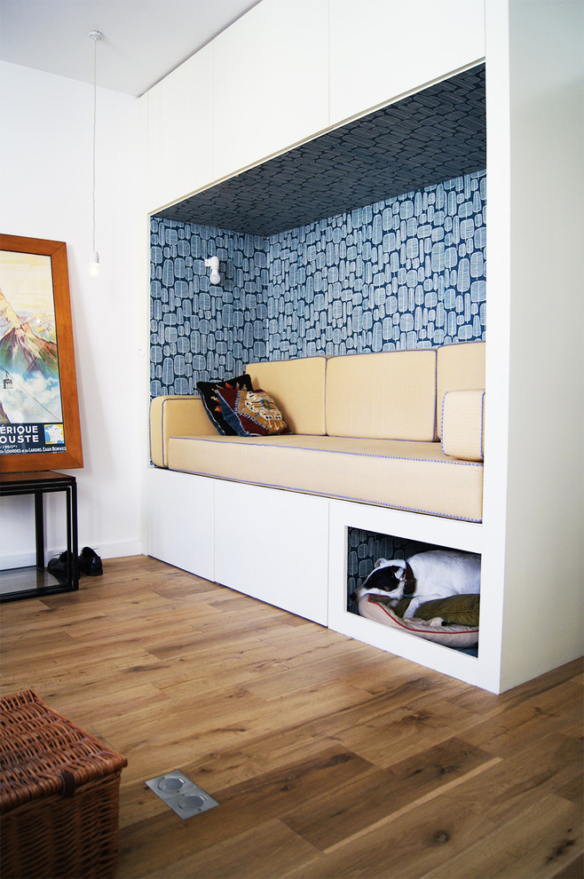 Пример оригинального дизайна: маленькая открытая гостиная комната в скандинавском стиле с с книжными шкафами и полками, белыми стенами и паркетным полом среднего тона без камина, телевизора для на участке и в саду