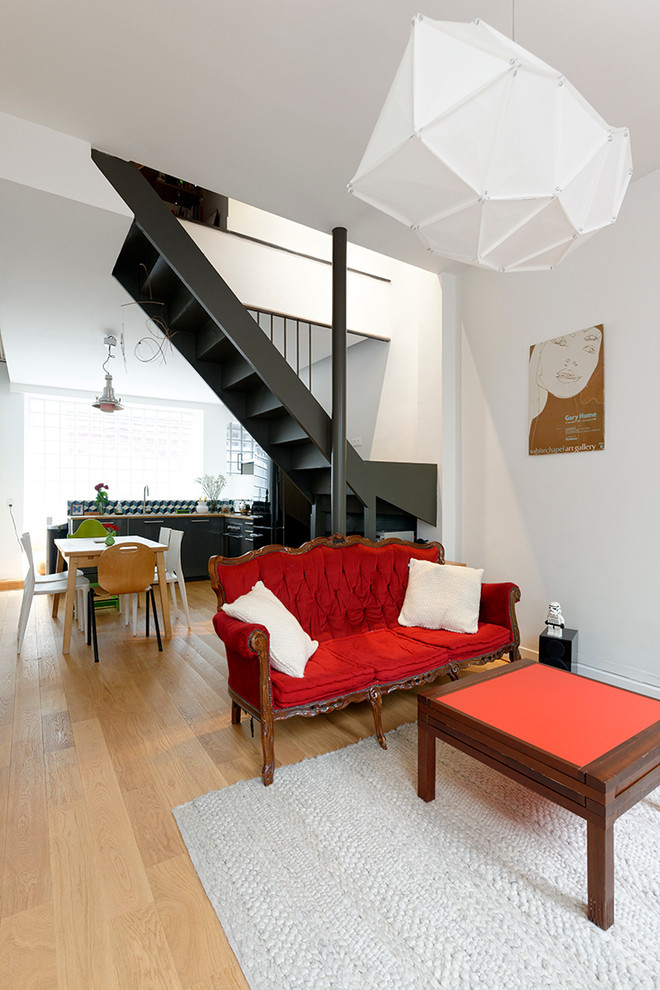 Imagen de salón abierto actual de tamaño medio sin chimenea y televisor con paredes blancas y suelo de madera clara