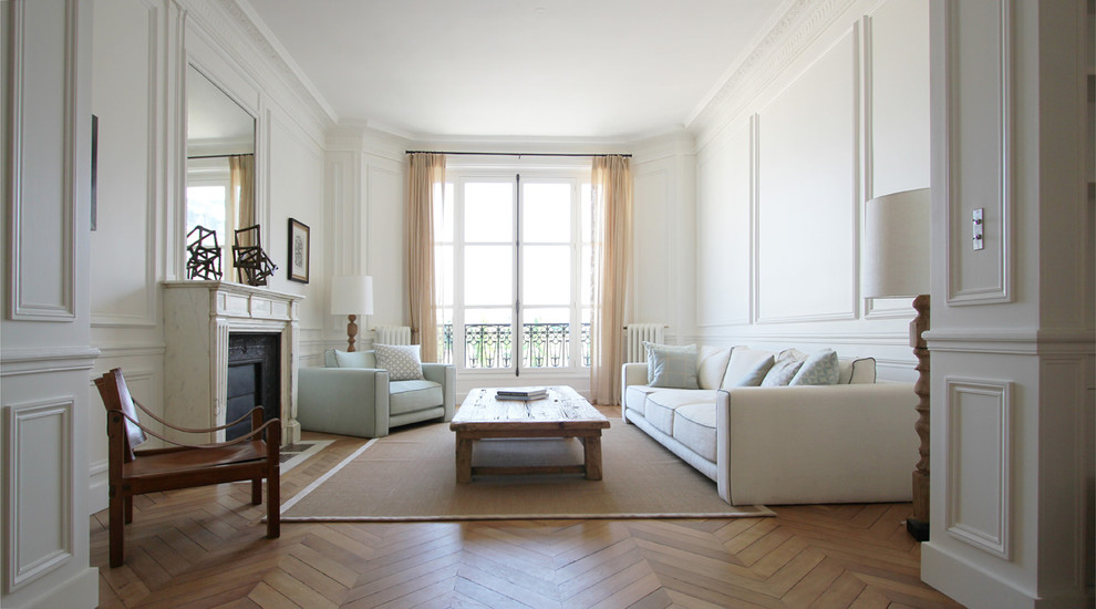 Großes, Repräsentatives, Fernseherloses, Abgetrenntes Klassisches Wohnzimmer mit weißer Wandfarbe, braunem Holzboden, Kamin und Kaminumrandung aus Stein in Paris