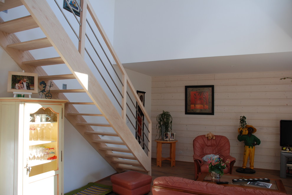 Cette image montre un salon traditionnel avec un mur blanc et un sol en bois brun.