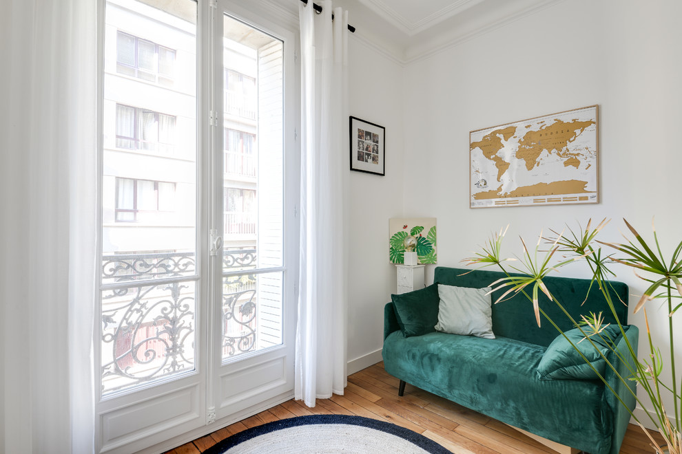 Inspiration for a small contemporary enclosed living room in Paris with a reading nook, white walls, medium hardwood flooring and a freestanding tv.