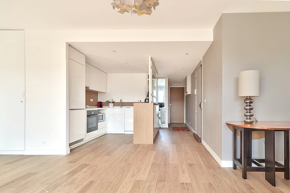 Mittelgroßes, Offenes Modernes Wohnzimmer ohne Kamin mit Hausbar, grauer Wandfarbe, hellem Holzboden und freistehendem TV in Paris